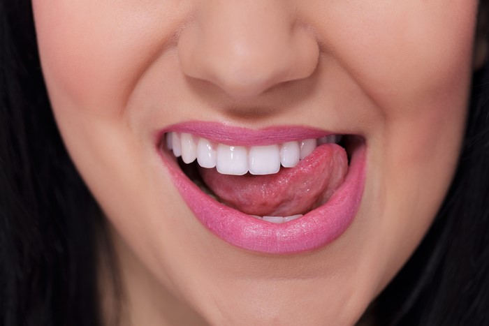 Close-up of woman's lips with tongue and teeth