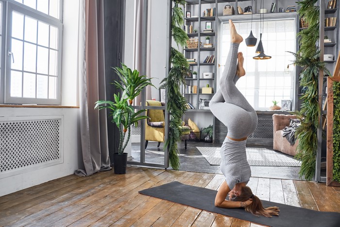 Woman doing a headstand yoga pose indoors