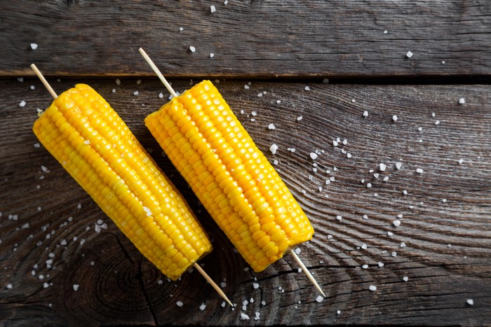 Two Corn Cobs with Salt on Wood
