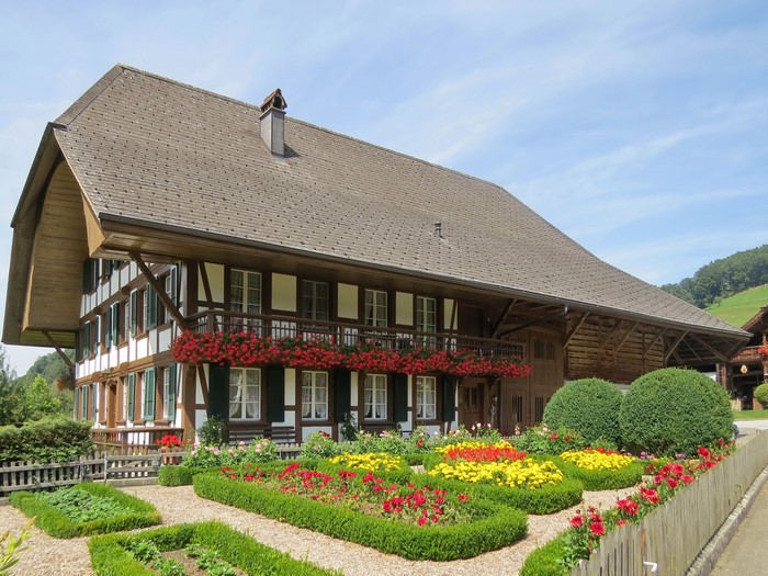 Traditional Swiss farmhouse with flower garden in Lutzelfluh, Switzerland
