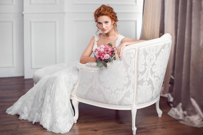 Bride with bouquet sitting on armchair