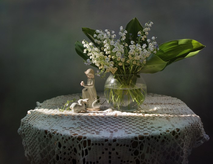 Lily of the valley in a vase with figurines