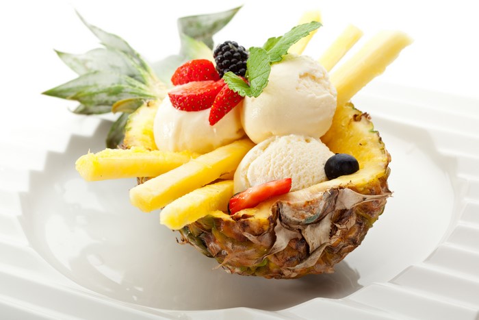 Pineapple boat with ice cream and berries