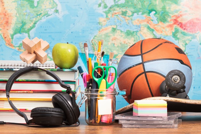 School supplies and sports equipment on a world map