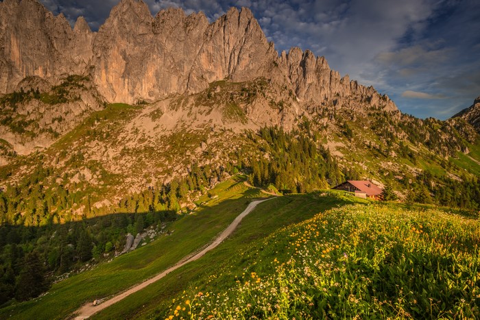 Mountain range with a house and a trail in Switzerland