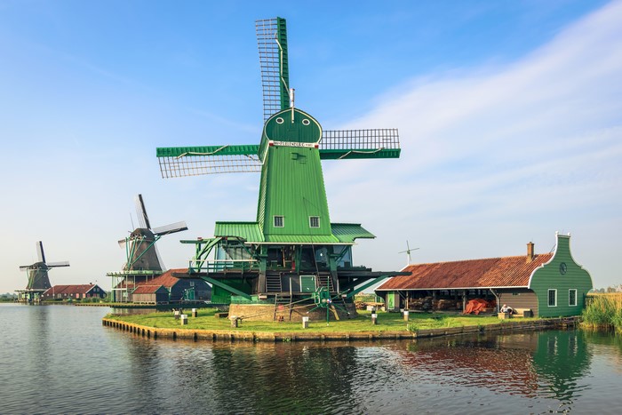 Green windmills on a river in Zaanse Schans, Netherlands
