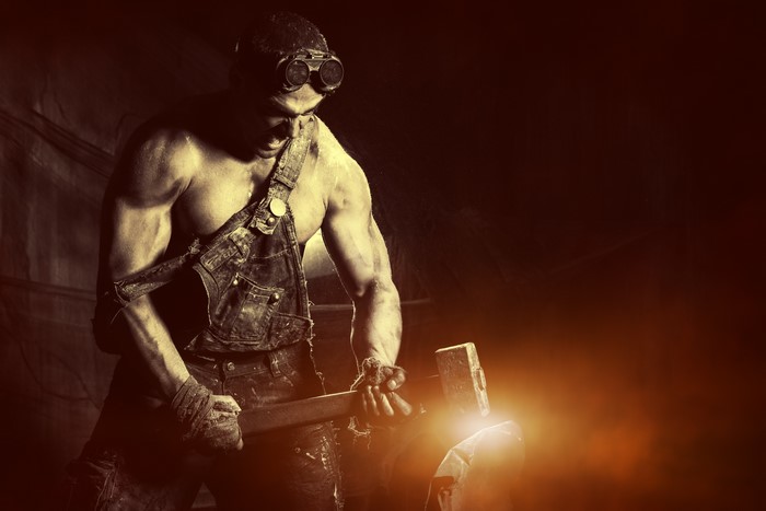 Man in overalls and goggles as a blacksmith
