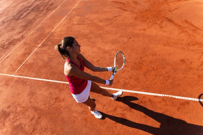 Woman playing tennis on a clay court