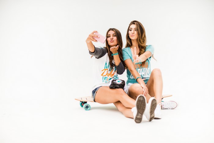 Two young women taking a selfie on a skateboard