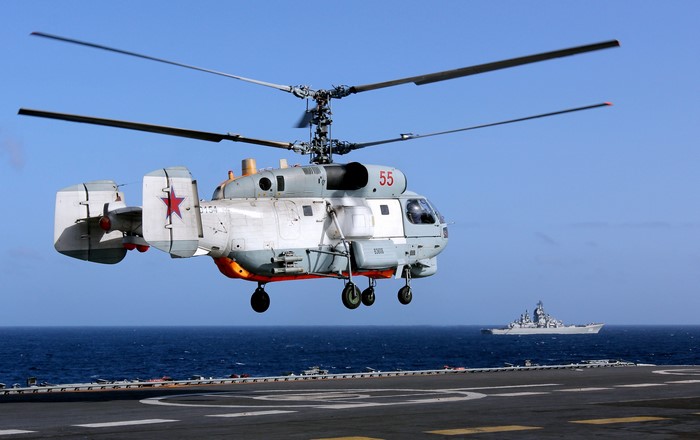 Kamov Ka-27 helicopter flying near a warship