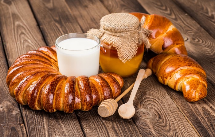 Pastry, Honey, Milk, and Croissants on Wood