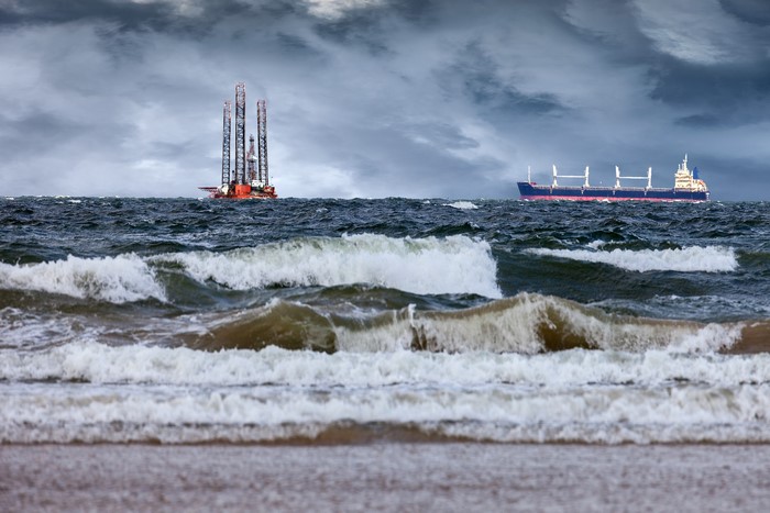 Oil rig and cargo ship on stormy sea