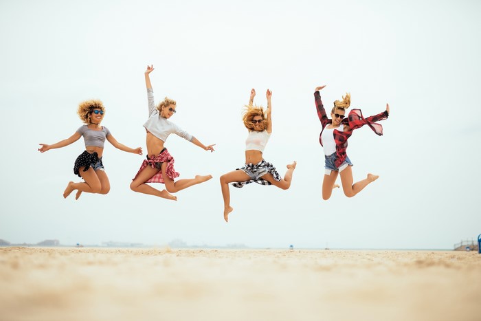 Four women jumping on a beach
