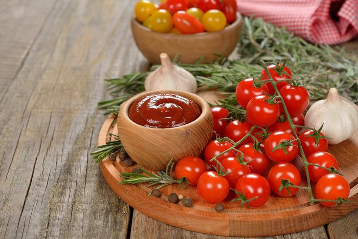 Tomatoes, Ketchup, Garlic, and Rosemary on a Wooden Board