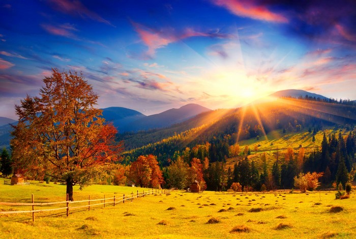 Autumn landscape with sunbeams over hills