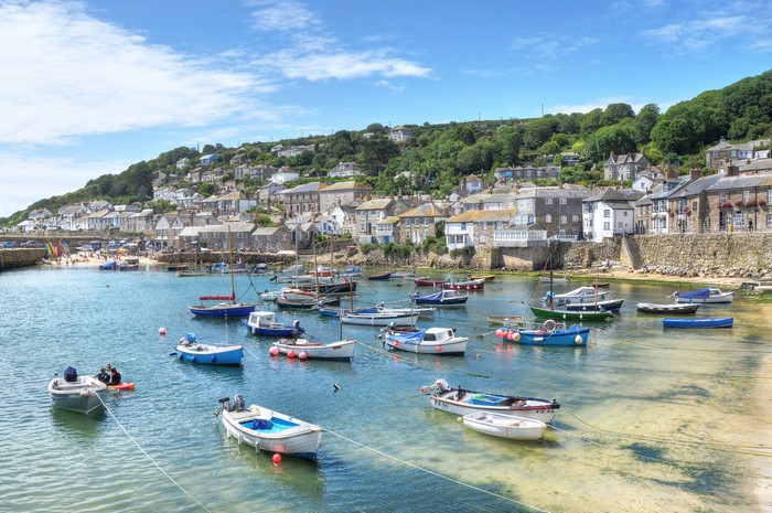 Mousehole, England harbor with boats and houses on a hill