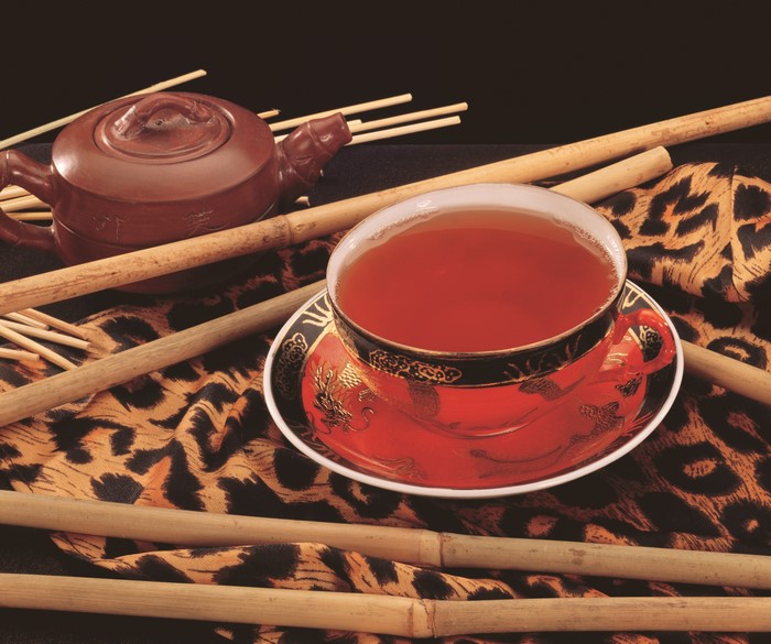 Tea in a cup and saucer with teapot and bamboo