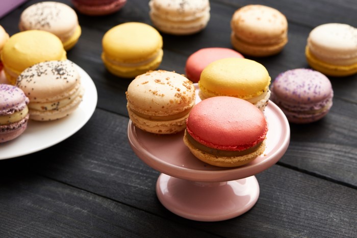 Assortment of colorful macarons on a dark wooden surface