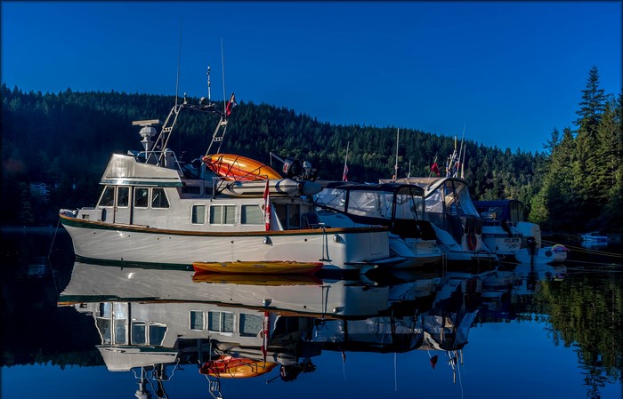 Boats docked in Coombe, British Columbia with reflections