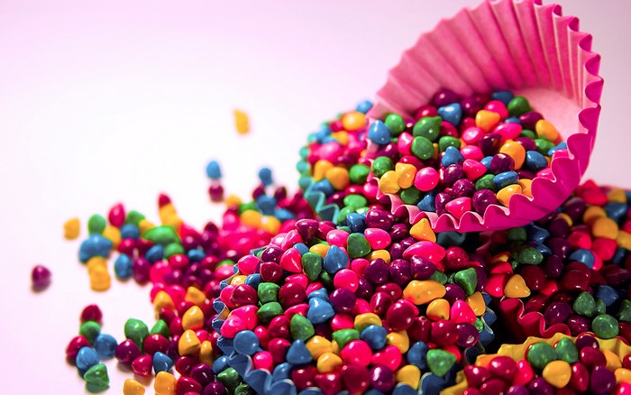 Spilled colorful candies in cupcake liners