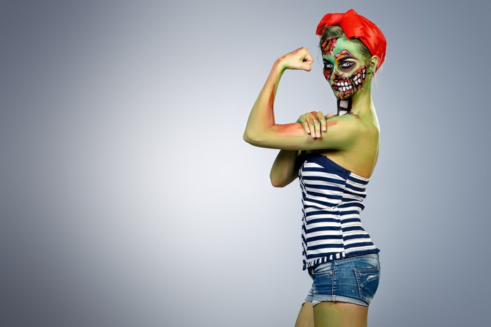 Zombie woman with makeup flexing arm