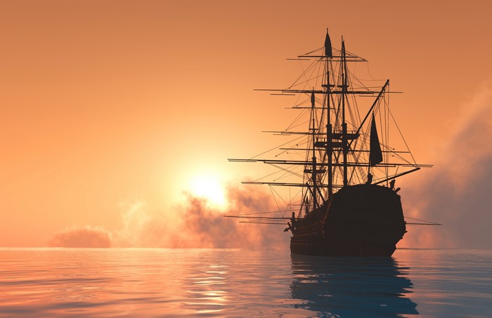 Silhouette of a sailing ship at sunset