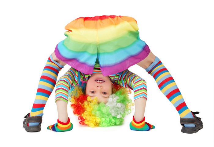 Little girl in clown costume doing a handstand