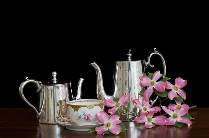 Silver teapots and teacup with pink dogwood flowers