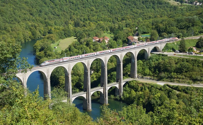 Train crossing a viaduct over a river in France