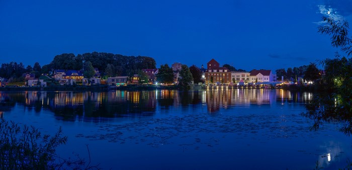 Town on a river at dusk with reflections