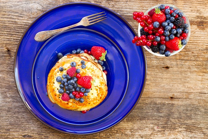 Pancakes with Berries on a Blue Plate with Fork
