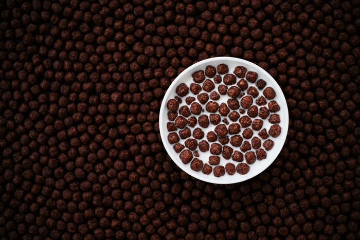 Chocolate cereal balls in milk in a white bowl