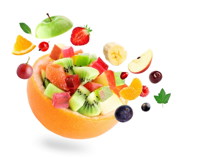 Fruit salad in a grapefruit bowl with flying fruits