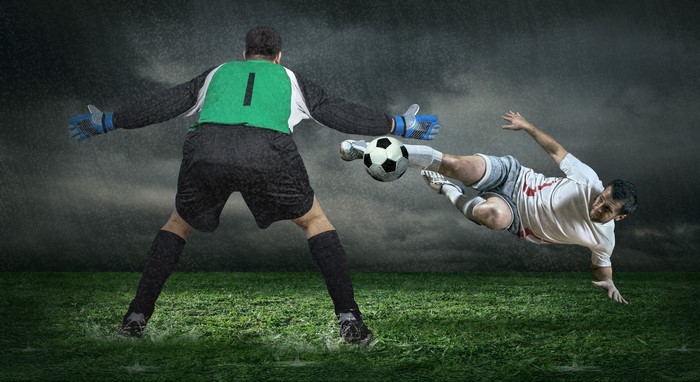 Goalkeeper and Soccer Player in Rain