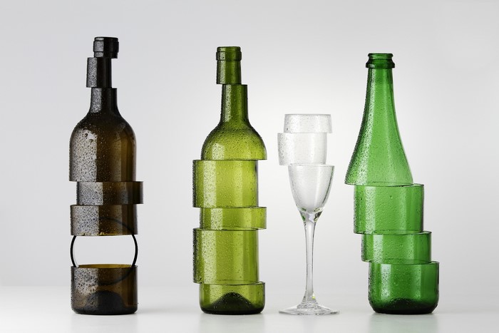 Sliced glass bottles and stemware on gray background