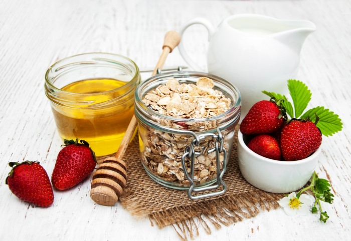 Muesli, strawberries, honey, and milk for breakfast