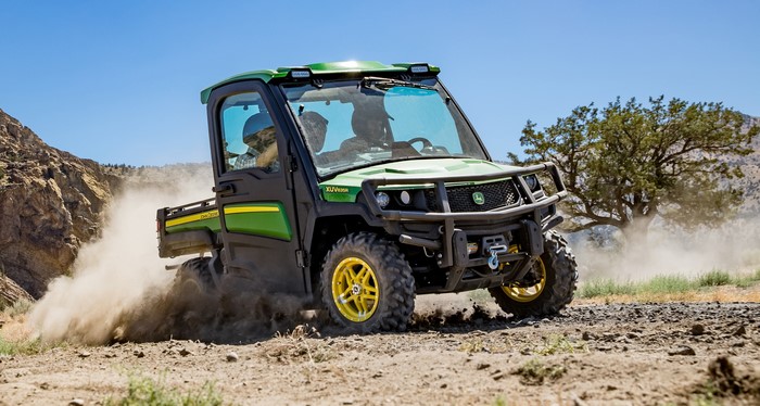 John Deere Gator XUV835R driving on dusty terrain