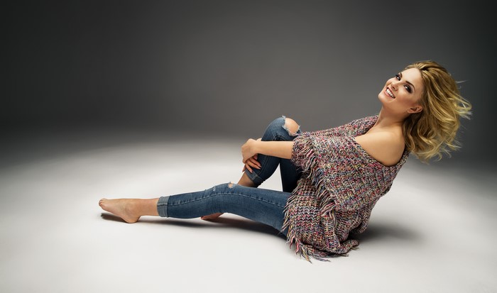 Woman in Jeans and Sweater Sitting