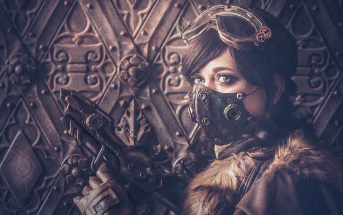 Steampunk woman with goggles and mask holding a pistol