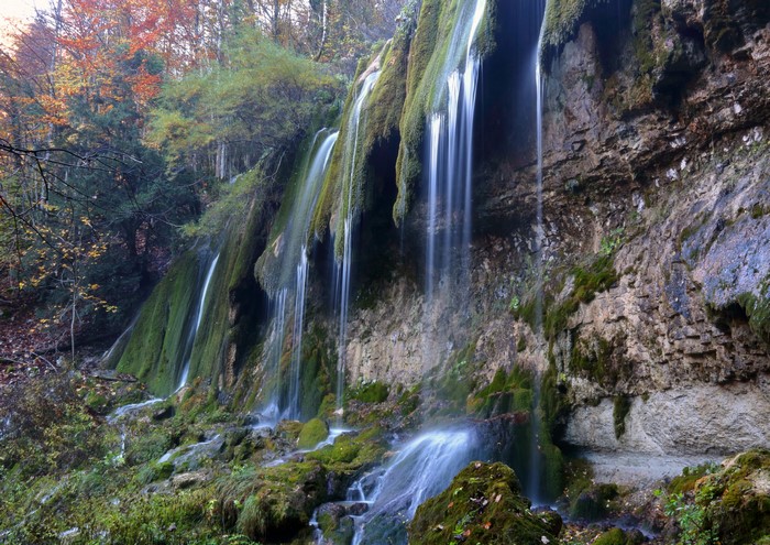 Mossy waterfalls cascading down a rocky cliff face