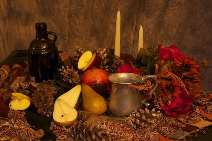 Still-life with pears, apples, pomegranate, bottle, mug, candles, and flowers