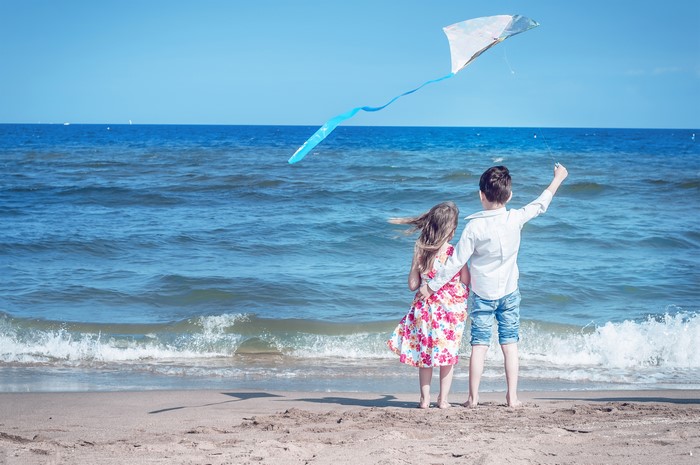 Children flying a kite on the beach