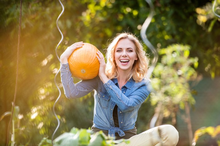 Blonde girl holding a pumpkin