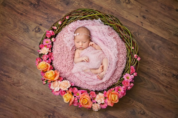 Newborn baby in floral wreath