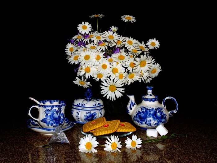 Still life with daisies, tea set, and cookies