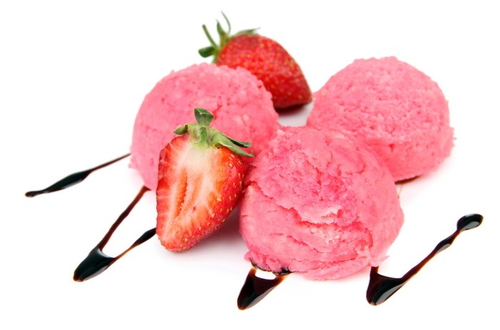 Strawberry ice cream scoops with chocolate drizzle and strawberries