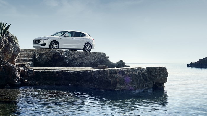 White Maserati Levante on rocky coast