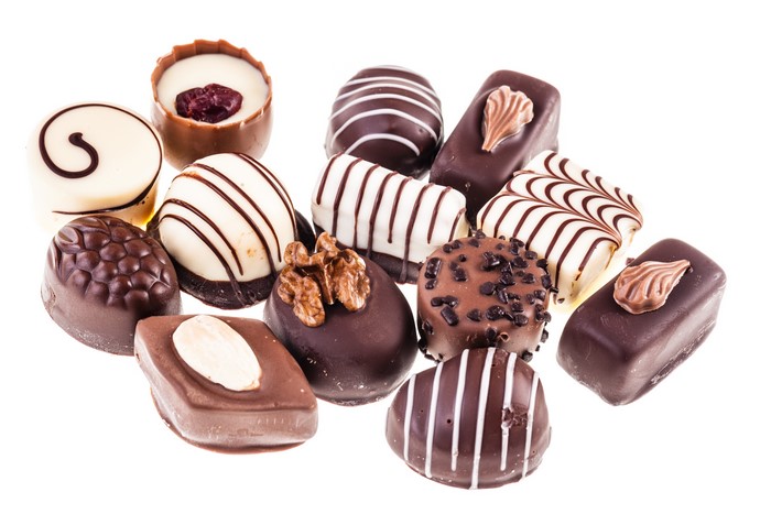Assortment of chocolates with nuts and white background