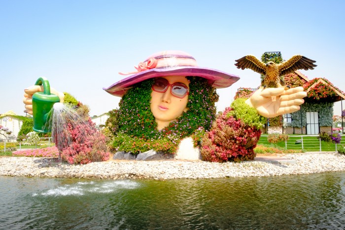 Floral sculpture of a woman with a hat and an eagle in Dubai Miracle Garden