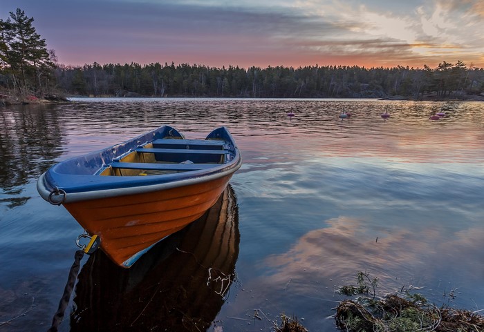 Orange and blue boat on a lake at sunset in Sweden